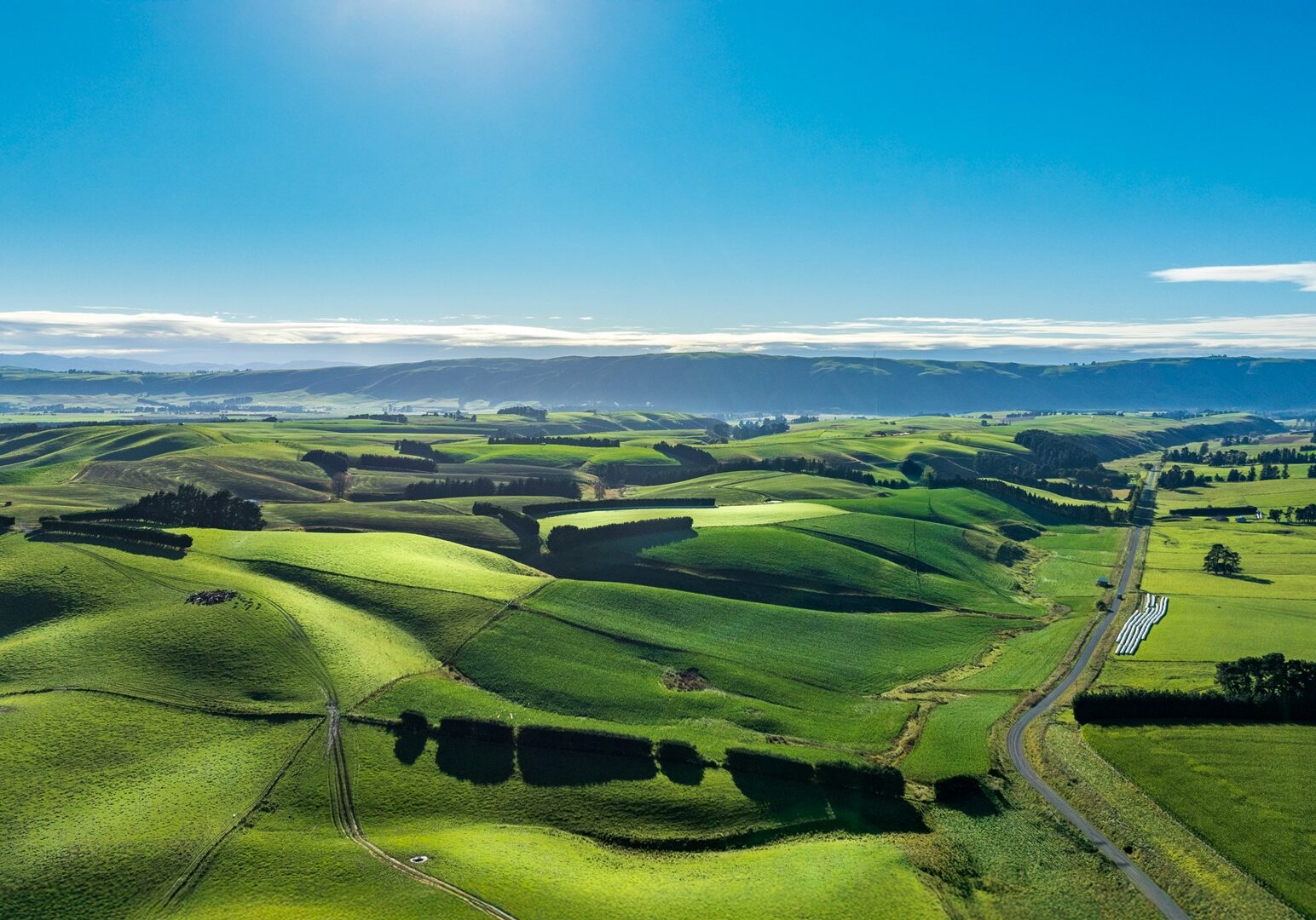 Aerial view driving through Camp Valley an agricultural farming countryside Rural country road winfing its way through agriculture and farm land in the heartland of the South Island NZ